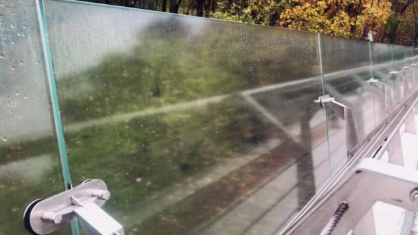 Grades de aço com ponte de vidro, após a chuva no outono, reflexo de pessoas que passam. — Vídeo de Stock