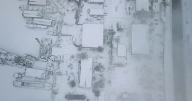 Endüstriyel alanın en üst görüntüsü. Rıhtımda bir mavna ve buzda donmuş su kaynağı var. Duman, üretimden çıkan buhar