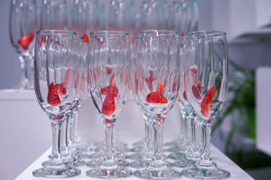 Konferansta canlandırıcı kokteyller için cam kadehlerle çilekli masa.