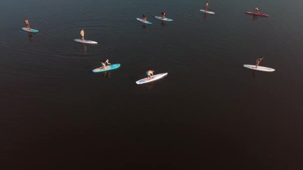 Flying over a group of people exercising on a sup board on a river against the backdrop of the city Ukraine, Kiev May 2019 — Stock Video