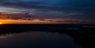 6 Mayıs 'ta Ukrayna, Kiev' deki inşaat evlerinin altındaki nehrin üzerindeki bulutlarla güzel bir gün batımı..