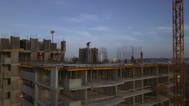 Yüksek bir binada çalışan bir işçi, akşamları beton dökme işini tıkıyor..