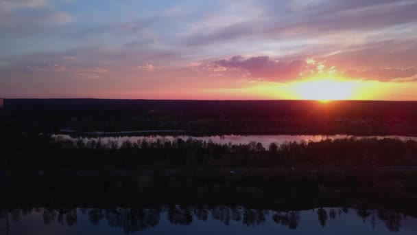 Kleurrijke zonsondergang over de baai vliegt de drone langzaam terug voor het bos en de weg Oekraïne, Kiev op 6 mei. — Stockvideo