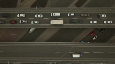 Yol kavşağı ve köprülerin üst görüntüsü. Araba şeritlerinden biri yavaş hareket ediyor..