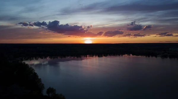 Beautiful sunset with clouds over the river under construction houses in the dark, Ukraine, Kiev on May 6. — Stock Photo, Image