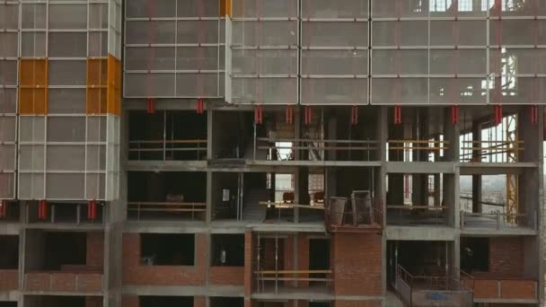 De camera zoomt naar beneden langs een staand gebouw met lege plafonds gemaakt van beton bakstenen en beschermende structuren. — Stockvideo