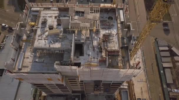 The camera descends on a house under construction with working builders and a crane Ukraine Kiev obolon 2021 May 11 — Video