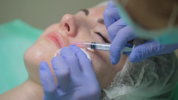 O esteticista faz um procedimento de tratamento para o paciente. Um esteticista dá injeções a um rosto de mulher. Mesoterapia. Médico em luvas médicas injectadas injecções — Vídeo de Stock