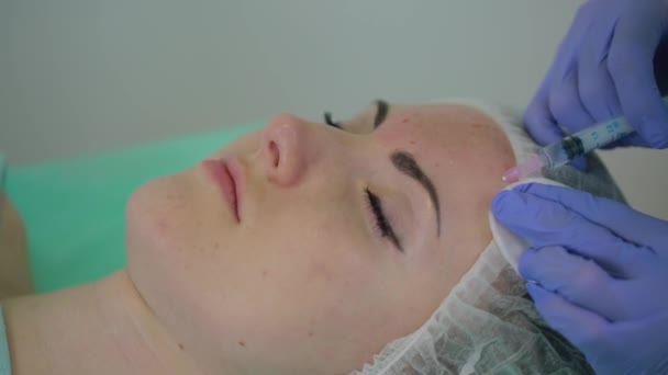 미용사는 환자를 치료 한다. 미용사는 여자들의 얼굴에 주사를 놓는다. 메소 요법. 의료 장갑을 끼고 주사를 놓는 의사 — 비디오