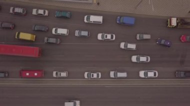 Akşamüstü trafiğin yoğun olduğu bir kavşakta motosikletçiler bisiklet yolunda giderken alçak açılı drone uçuşu.. 