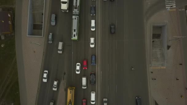 Tieffliegerdrohnenflug über eine massive Kreuzung im frühen abendlichen Berufsverkehr mit Radfahrern auf dem Radweg. — Stockvideo