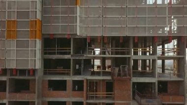 Kamera, beton tuğlalardan ve koruyucu yapılardan oluşan boş tavanlarla ayakta duran bir bina boyunca zumluyor..