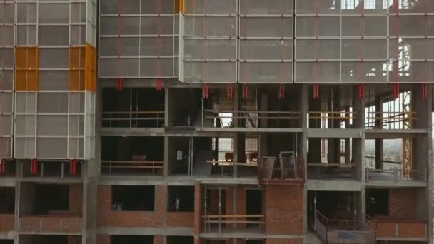 De camera zoomt naar beneden langs een staand gebouw met lege plafonds gemaakt van beton bakstenen en beschermende structuren. — Stockvideo