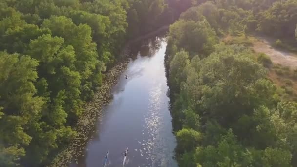 Fliegen über den Fluss an einem sonnigen, hellen Tag, Menschen ruhen sich auf Kajaks und Sapa aus, die Sonne blinzelt in die Kamera — Stockvideo