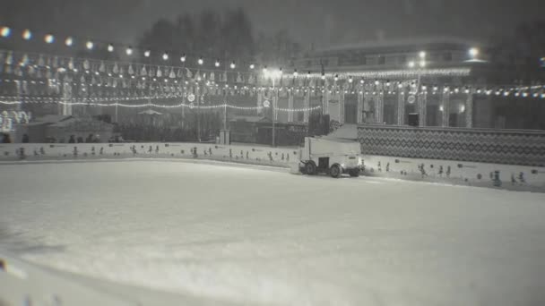 Machine de récupération et d'entretien de la glace sur une patinoire, soirée, lumières, chutes de neige. Ukraine, Kiev 14 janvier 2021 — Video