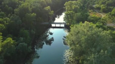 Güneşli bir günde nehrin üzerinde uçarken, insanlar kano ve sapa üzerinde dinlenirken, kamerada güneş parlarken