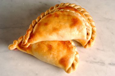 Beyaz arka planda iki börek, Arjantin yemeği.