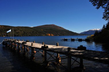 Arjantin neuquen patagonia, panoramik viux dağ trre ve lacar gölü mavi gökyüzü ahşap iskele