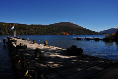 Arjantin neuquen patagonia, panoramik viux dağ trre ve lacar gölü mavi gökyüzü ahşap iskele