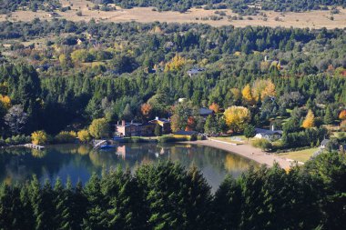 Sonbaharda ağaçlı orman ve soğuk bir sabah pintoresk neuquen arjantin panoramik viux akçaağaç lacar gölü lüks evi yapraklarının arasından güneş.