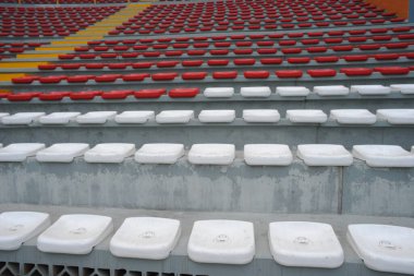 Arenanın tribünlerinde ya da konser salonundaki boş koltuklar. Seyircisi olmayan kırmızı ve beyaz koltuklar. Spor ve kitlesel eğlencenin kaldırılması kavramı