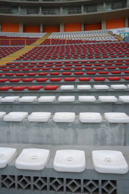 Arenanın tribünlerinde ya da konser salonundaki boş koltuklar. Seyircisi olmayan kırmızı ve beyaz koltuklar. Spor ve kitlesel eğlencenin kaldırılması kavramı