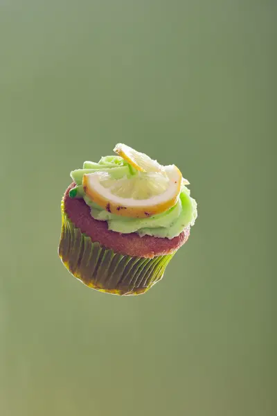 Yeşil arka plan üzerinde yüzen cupcake