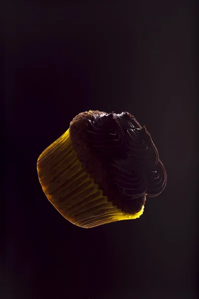 karanlık bir arka plan üzerinde yüzen cupcake