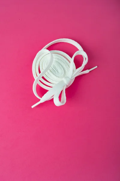 Spor Ayakkabı bağcıklarımı pembe bir arka plan üzerinde