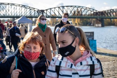 PRAG, CZECH REPUBLIC - 24 Ekim 2020: Koronavirüs salgınının ikinci dalgası sırasında Naplavka çiftçi pazarında maskeli kadınlar alışveriş yapıyor