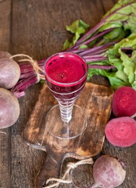 Masada bir bardak kırmızı arı suyu.