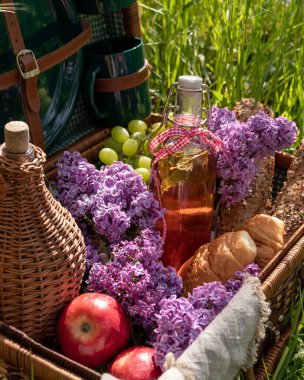Açık havada piknik sepetinde bir şişe meyve suyu.