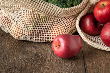 Organik pamuktan yapılmış ekolojik olarak yeniden kullanılabilir bir ağ torbasında taze elmalar.