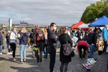 PRAG, CZECH REPUBLIC - 25 Nisan 2020: Coronavirus salgınının ilk dalgasının sonunda yeniden açılan Naplavka çiftçi pazarındaki yüz maskeli insanlar