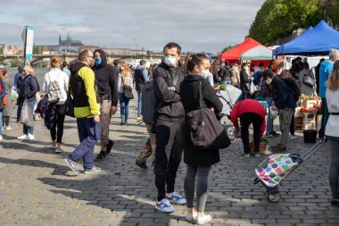 PRAG, CZECH REPUBLIC - 25 Nisan 2020: Koronavirüs salgınının ilk dalgasının sonunda yeniden açılan Naplavka çiftçi pazarında koruyucu maskeler takan insanlar