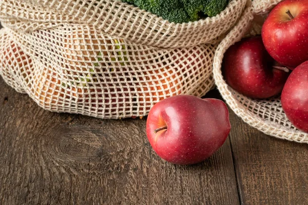 Organik pamuktan yapılmış ekolojik olarak yeniden kullanılabilir bir ağ torbasında taze elmalar.