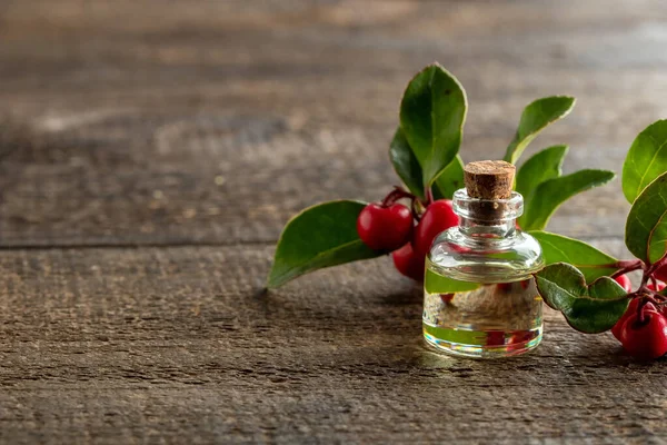 Una Botella Aceite Esencial Con Hojas Verdor Invernal Bayas Con —  Fotos de Stock