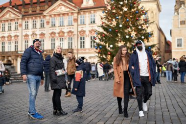 PRAGUE, CZECH REPUBLIC - 5 Aralık 2020: Eski Şehir Meydanı 'ndaki insanlar, bazıları koronavirüs salgınından dolayı maske takıyor, arka planda Noel ağacı var