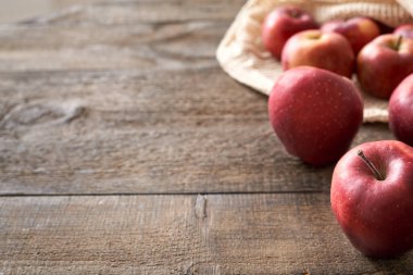 Masada kırmızı elmalar, arka planda organik pamuktan yapılmış ekolojik yeniden kullanılabilir ağ torbası, fotokopi alanı ile