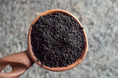 Tahta kaşıkta siyah kimyon tohumları, üst manzara.