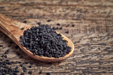 Masadaki tahta kaşıkta siyah kimyon tohumları