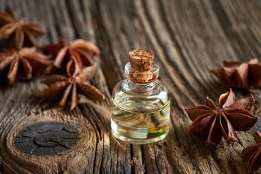 Ahşap zemin üzerinde yıldız anason olan bir şişe gerekli yağ.