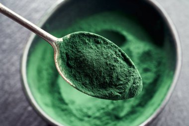 Yerdeki spirulina yosunları kaşıkta ve kasede