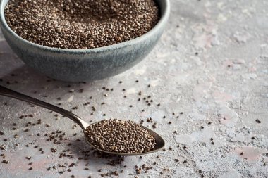 Metal kaşıkta Chia tohumları açık gri bir zemin üzerinde kopya alanı ile