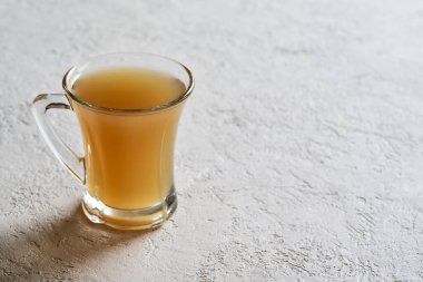 Beyaz zemin üzerinde bir bardakta sığır kemiği çorbası ve kopyalama alanı