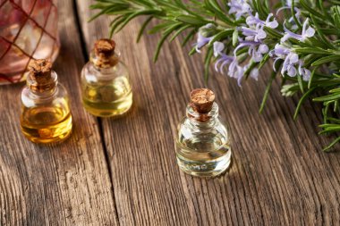 Çiçek açan biberiye dallarıyla gerekli yağ şişeleri.