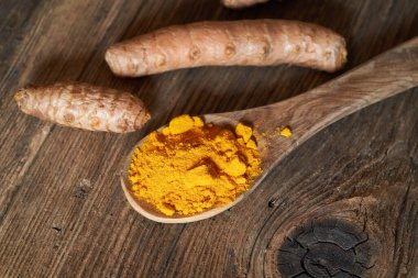 Zerdeçal tozu ve tüm kök, yakın plan.