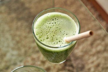 Bambu kamışla cam bir masada yeşil meyve suyu - sıfır atık ya da ekoloji konsepti