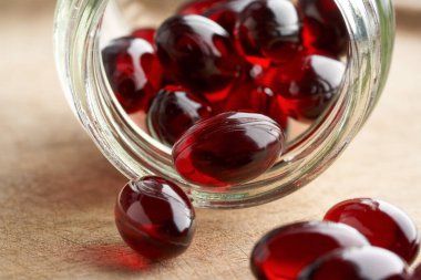 Kril yağı kapsülleri cam bir şişeden dökülüyor, yaklaşın.