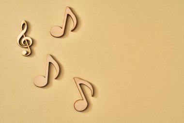 Sarı arkaplan üzerine ahşap notalar, kopya alanı ile üst görünüm